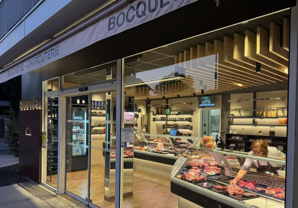 The Boucherie Bocquet shopfront at 16 rue Louis Boch in Annecy, windows lit at dusk