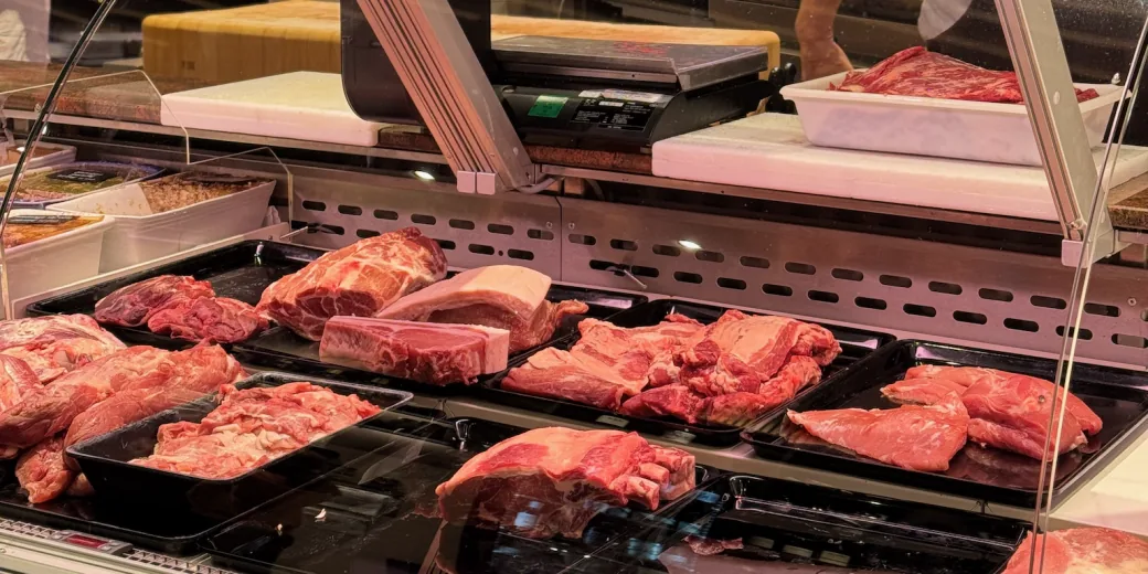The refrigerated display at Boucherie Bocquet, trays of meat and chopping boards