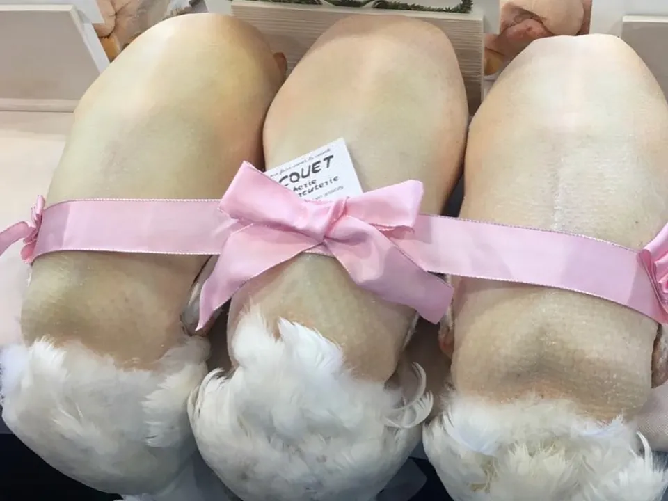Three Bresse birds tied with a pink ribbon, ready for the festive season.